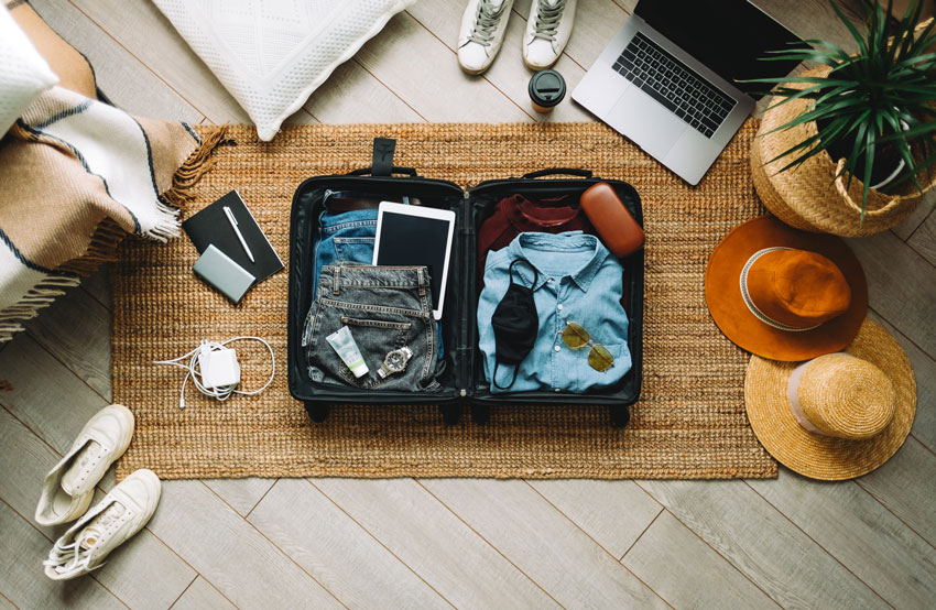 suitcase laid on floor packing for vacation or trip