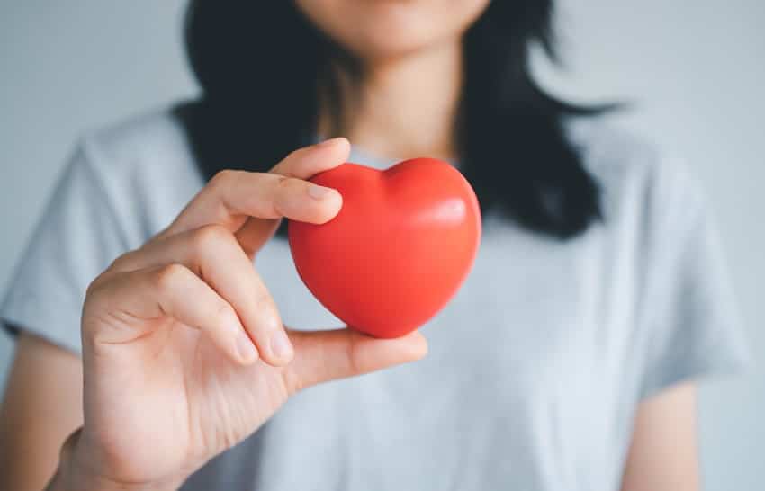 adult woman holding a red foam heart