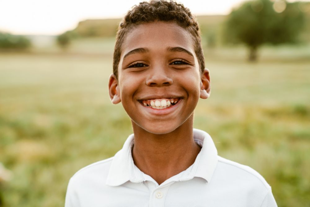 Early childhood ortho 2 Young boy in white polo shirt smiling